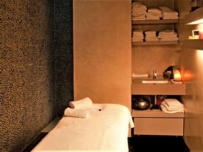 Przytulny pokój do masażu z ciepłymi kolorami i starannie ułożonymi ręcznikami.