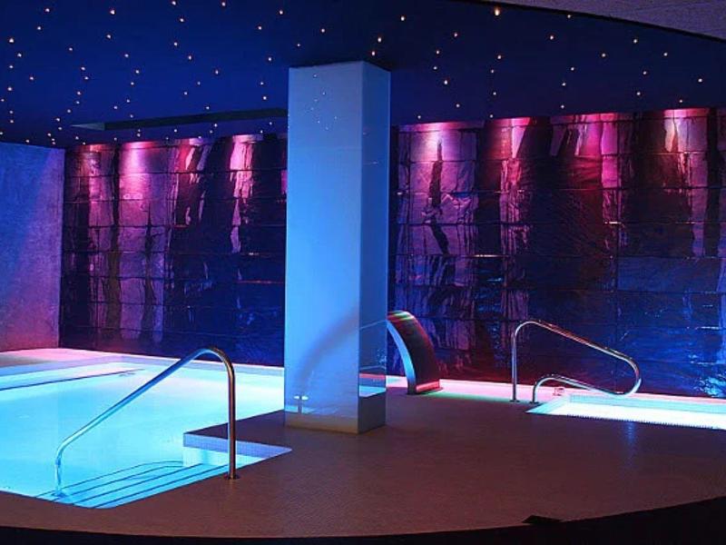 Basen kryty z nowoczesnym oświetleniem i ścianą wodospadu w luksusowym hotelu