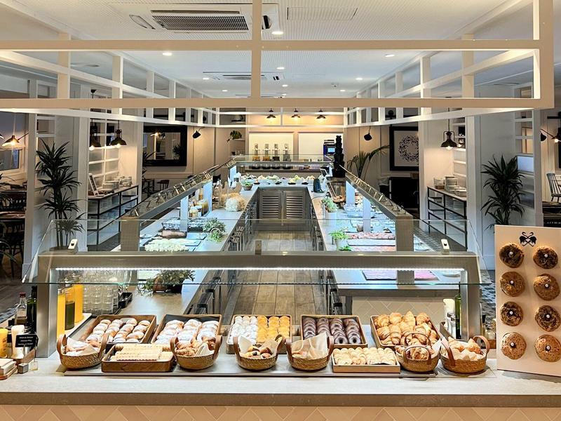 Area colazione moderna con una varietà di prodotti da forno e un'atmosfera luminosa e accogliente.