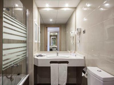 Bagno moderno e luminoso con lavabo, WC e cabina doccia in vetro.