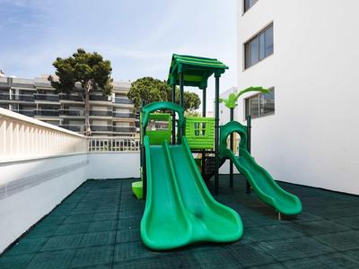 Area giochi verde con scivoli sulla terrazza di un hotel.