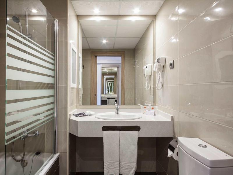 Bagno moderno e luminoso con lavabo, WC e cabina doccia in vetro.