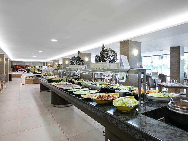 Area buffet con una varietà di piatti in un ambiente moderno di ristorante.