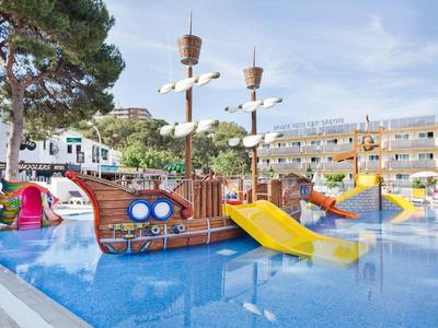 Outdoor water playground with pirate ship, slides, and colorful play structures in a hotel pool area.