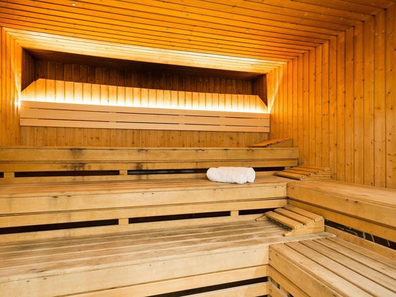 Wooden sauna interior with benches and a towel on one bench.