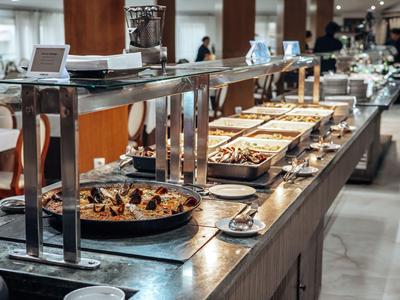 Bufet z różnymi gorącymi i zimnymi potrawami w nowoczesnej restauracji hotelowej.