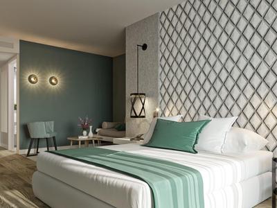 Nowoczesny pokój hotelowy z łóżkiem podwójnym, zielonymi akcentami i przytulną atmosferą.