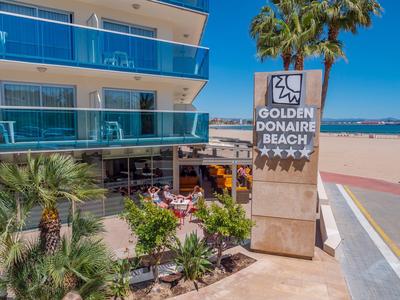 Hotel z balkonem, palmami i znakami na plaży pod czystym niebem