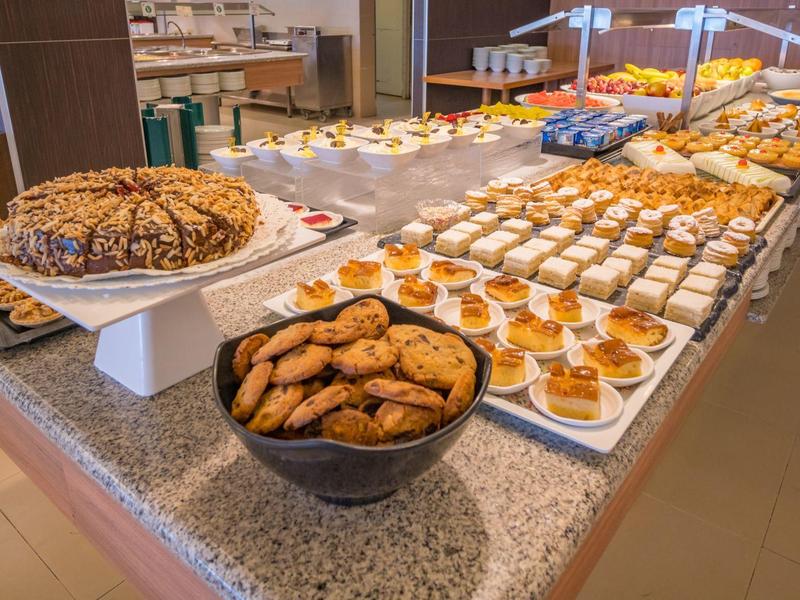 Bufet z różnorodnymi ciastkami i deserami na długim stole w hotelu.