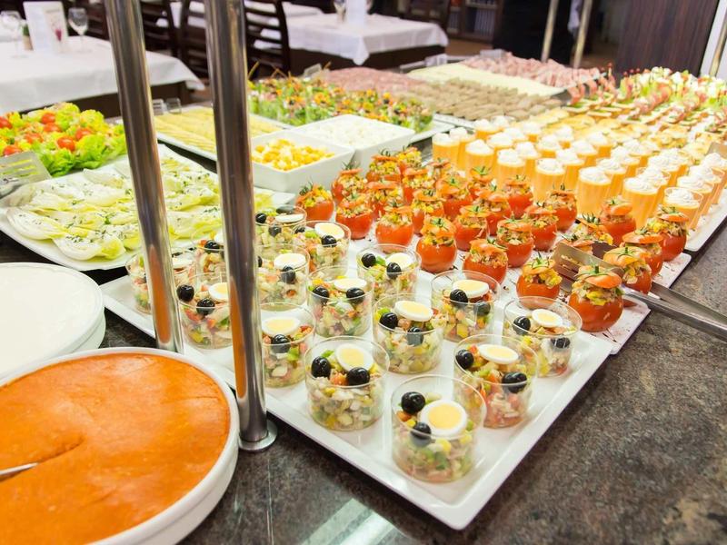 A buffet with various appetizers including shrimp, salad, and sauce dishes.
