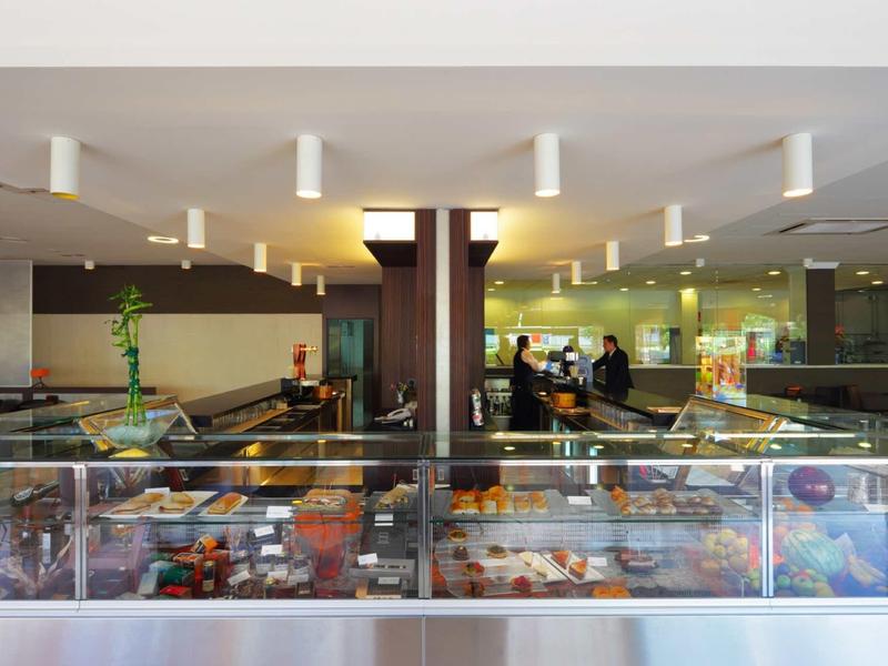 Display case with assorted desserts and pastries in a modern bakery or cafe interior.