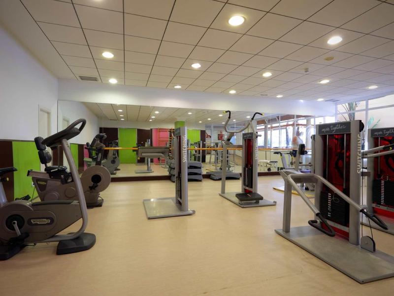 Spacious gym with fitness machines and bright ceiling lights