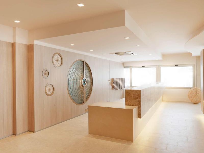 Moderner, heller Raum mit Holzvertäfelungen, runden Wanddekorationen und großen Fenstern.