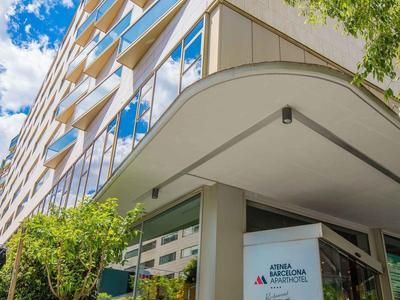 Ingresso di edificio moderno su più piani con vetro e piante sotto cielo azzurro