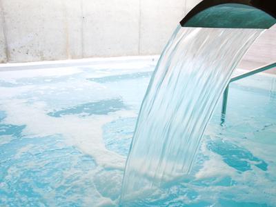 Acqua limpida scorre da una bocca in una piscina frizzante.