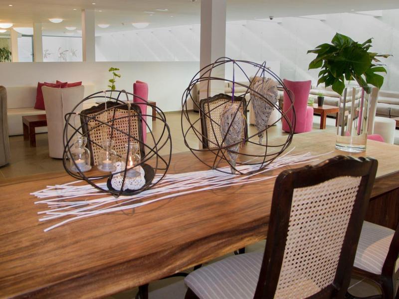 Tavolo da pranzo con superficie in legno, biciclette decorative in filo metallico e due sedie in una stanza luminosa.