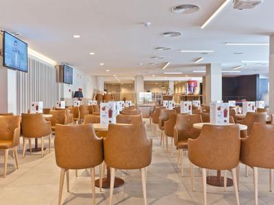 Heller, moderner Hotel-Speisesaal mit braunen Stühlen und Tischen, klar und ordentlich.