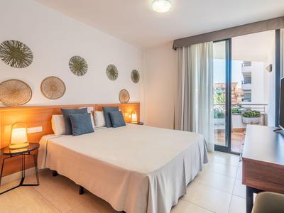 Modern eingerichtetes Hotelzimmer mit Doppelbett, Balkon und stilvoller Wanddekoration.