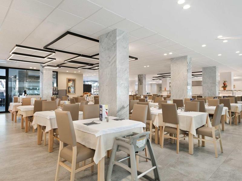 Spacious, modern restaurant with neatly arranged tables and chairs in neutral tones.