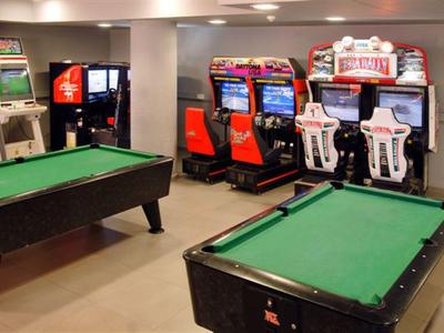 A room with two pool tables and arcade machines in the background.