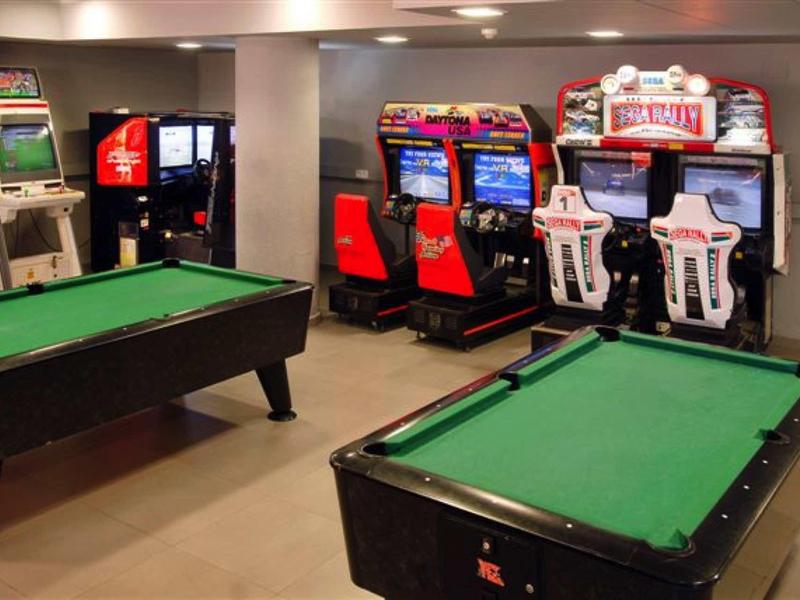 Herna s kulečníkovými stoly, videohrami a výherními automaty v hotelu.