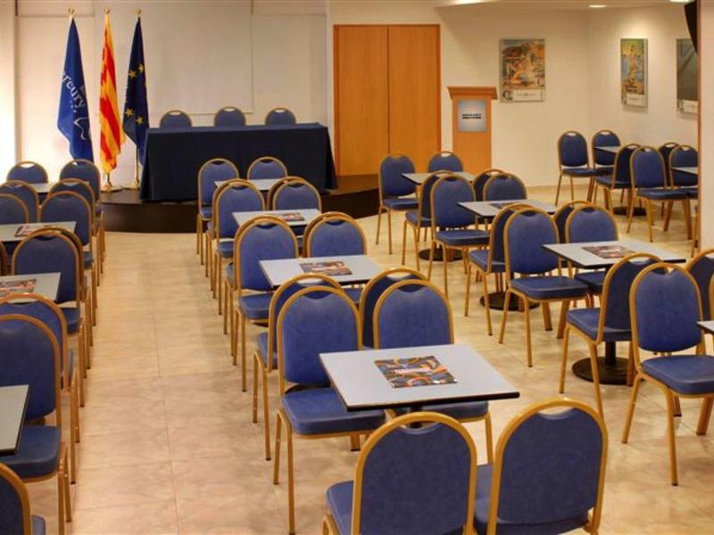 Učebna s modrými židlemi a stoly připravená na prezentaci.