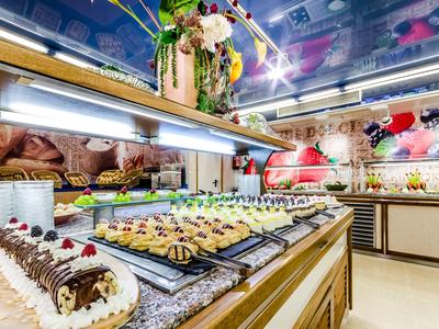 Buntes Kuchenbuffet mit verschiedenen Torten und Gebäck in einem hellen, dekorierten Raum.