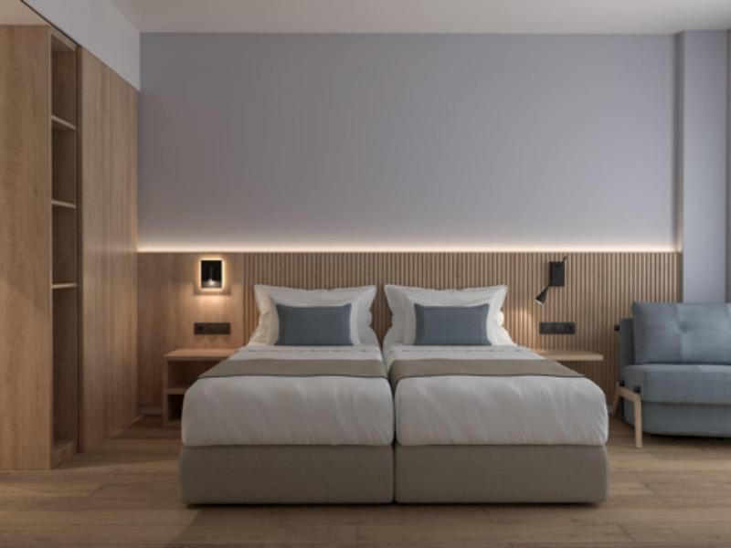 Modernes Schlafzimmer mit zwei Einzelbetten, Holzvertäfelung, grauem Sofa und großen Fenstern.