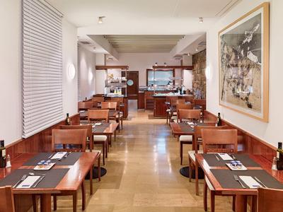 Salle à manger moderne et petite avec tables et chaises en bois, dressée pour deux, décor minimaliste.