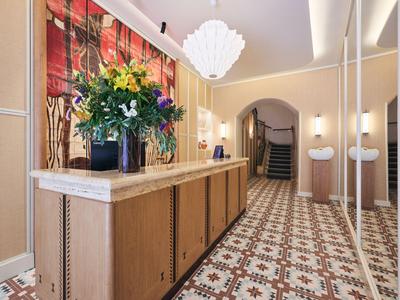 Heller Hotellobby-Empfangsbereich mit Blumendekoration und gemustertem Boden.