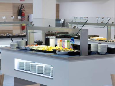 Espace buffet avec divers aliments et boissons dans une salle à manger moderne.