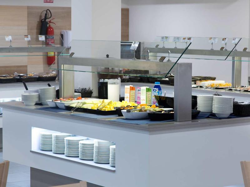 Espace buffet avec divers aliments et boissons dans une salle à manger moderne.