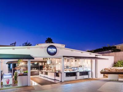 Modern hotel lobby with bright lighting and blue evening sky backdrop.
