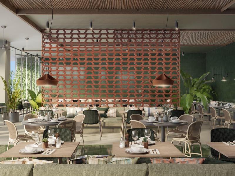 Ristorante spazioso con arredamento moderno, piante verdi e più tavoli con sedie.