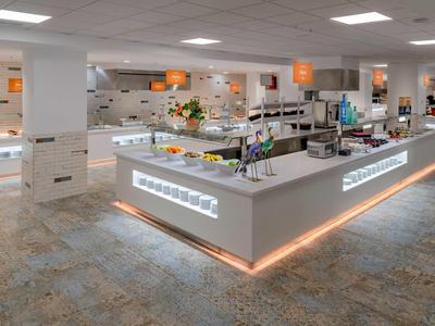 Buffet moderno y bien iluminado con variedad de alimentos en un restaurante elegante.