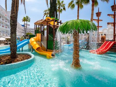 Wasserpark mit Rutschen, Palme und Pool in einem sonnigen Freizeitbereich.