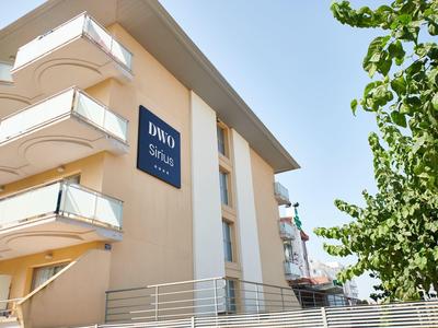 Edificio moderno dell'hotel con balconi e insegna blu sotto il sole.