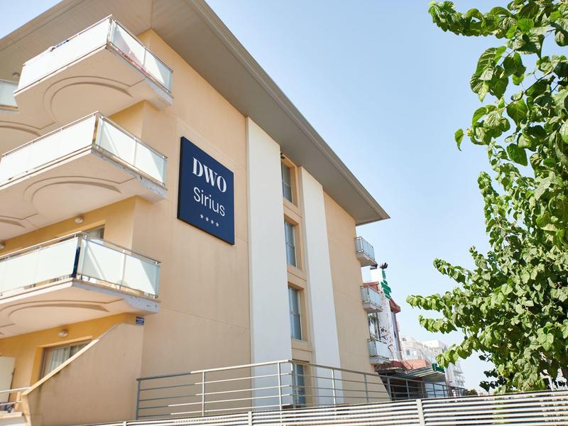 Edificio moderno dell'hotel con balconi e insegna blu sotto il sole.