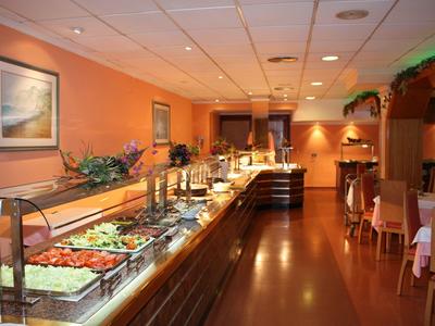 Buffetbereich in einem Restaurant mit verschiedenen Salaten und warmen Speisen in einer warm beleuchteten Umgebung.