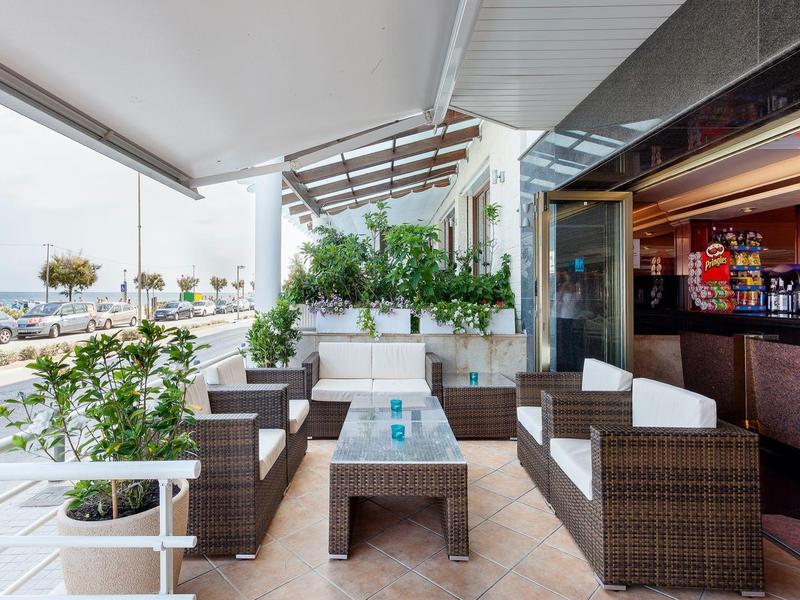 Moderner überdachter Sitzbereich mit Polstermöbeln und Blick auf das Meer