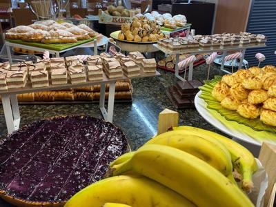 Varied buffet with fresh fruit, pastries, and cake in a hotel restaurant.