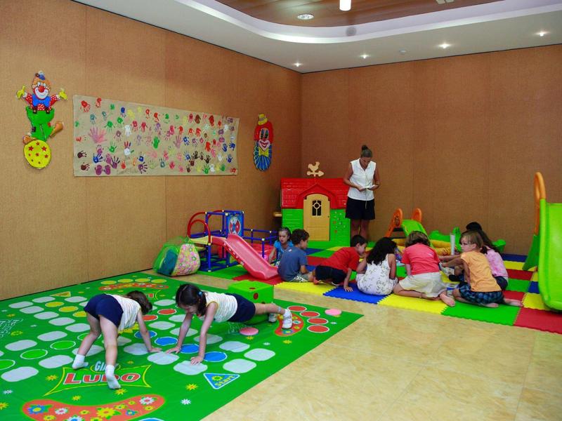 Dzieci bawią się w kolorowym wnętrzu z zabawkami i zjeżdżalniami.