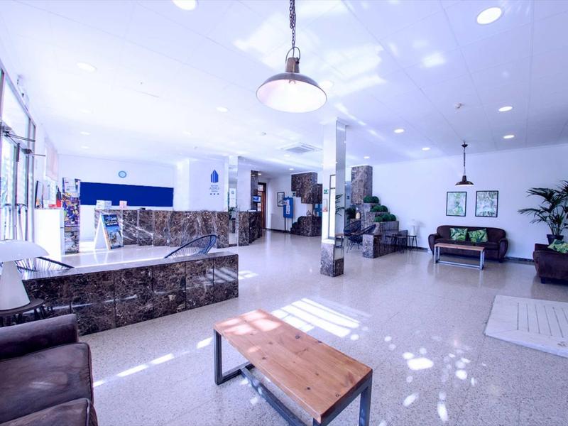 Luce moderna e luminosa hall d'hotel con aree salotto, reception e scala.