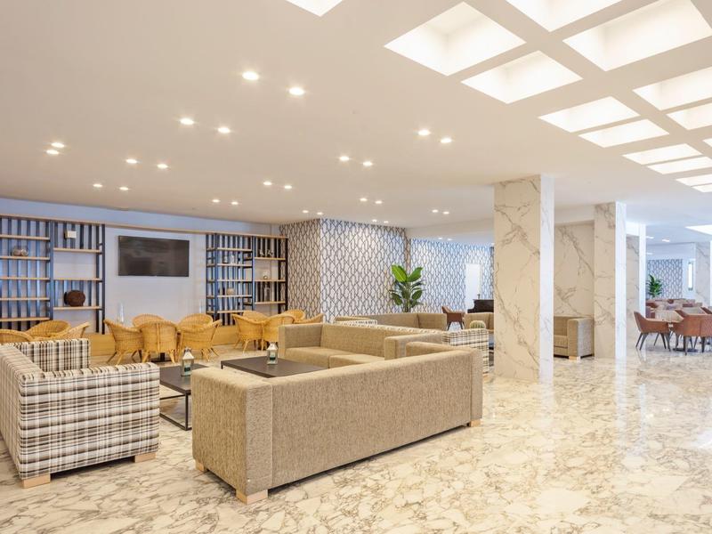 Hall d'hôtel moderne et lumineuse avec des espaces de détente confortables et un sol en marbre.