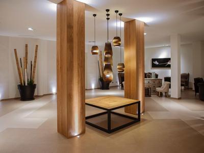 Nowoczesne lobby hotelowe z drewnianymi kolumnami i dekoracyjnymi lampami wiszącymi.