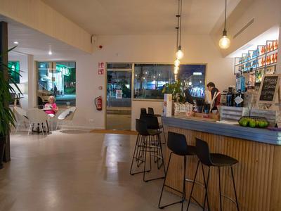 Nowoczesny bar hotelowy z ladą, stołkami i strefą wypoczynkową nocą.