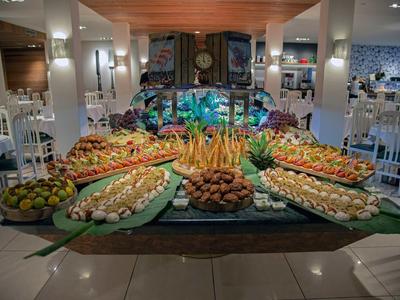 Bufet z różnorodnymi potrawami i dekoracyjnymi aranżacjami w eleganckiej jadalni.