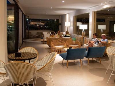 Przytulna przestrzeń wypoczynkowa hotelu z miejscami do siedzenia i gośćmi wieczorem.