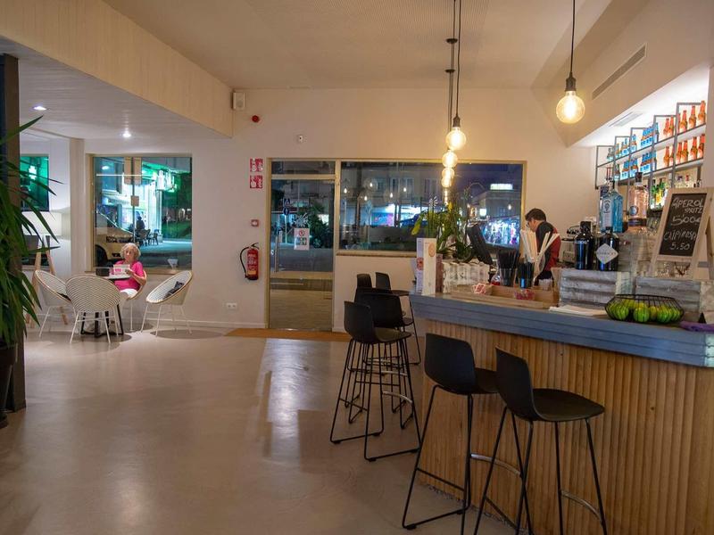 Nowoczesny bar hotelowy z ladą, stołkami i strefą wypoczynkową nocą.