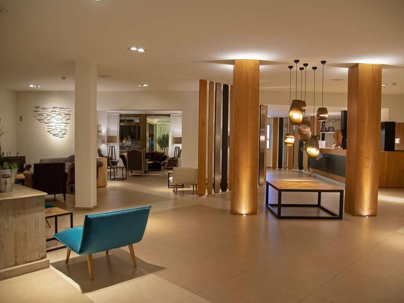 Nowoczesna lobby hotelowa z ciepłym oświetleniem i stylowymi miejscami do siedzenia.